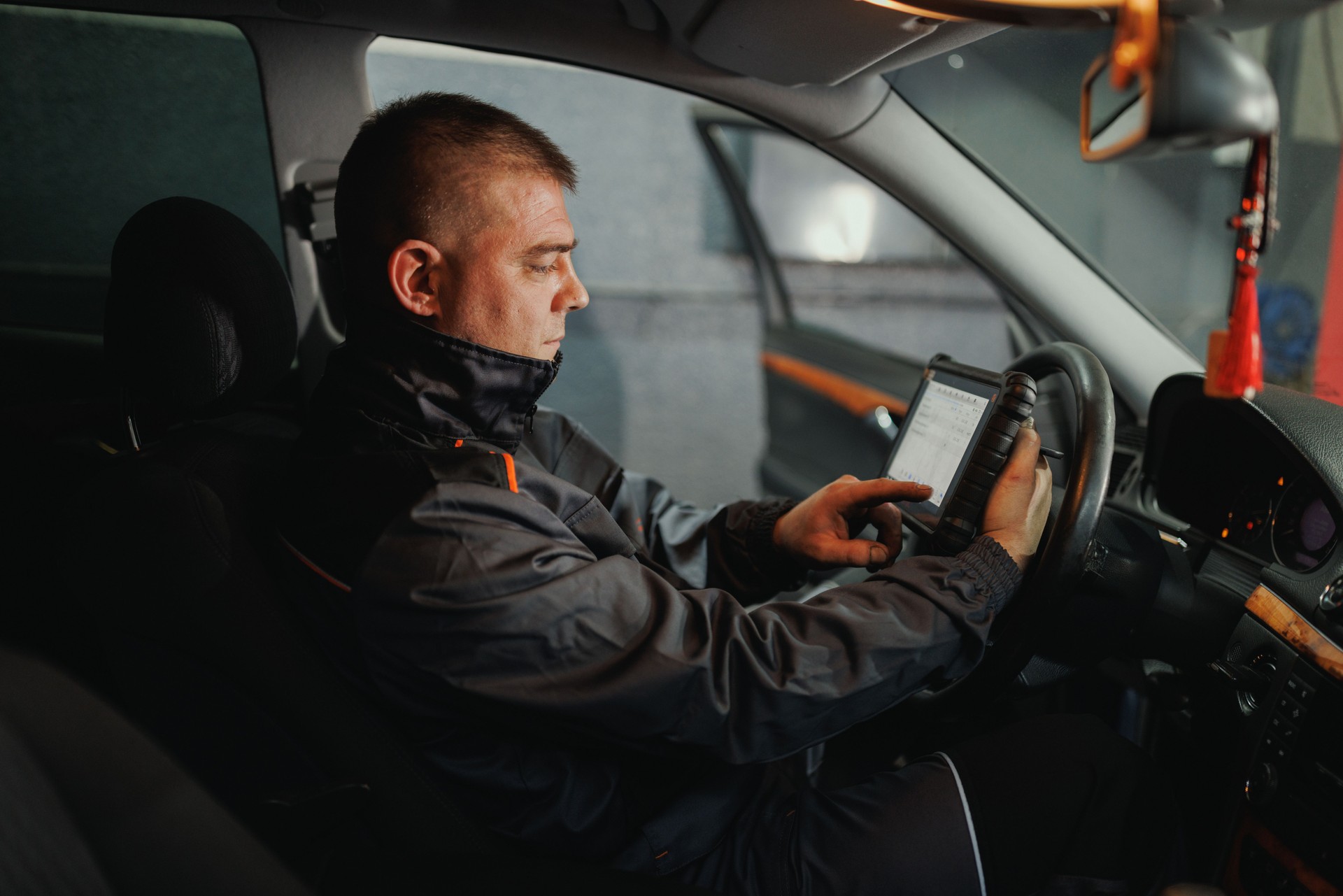 Auto Mechanic Running Diagnostics on Car Tablet