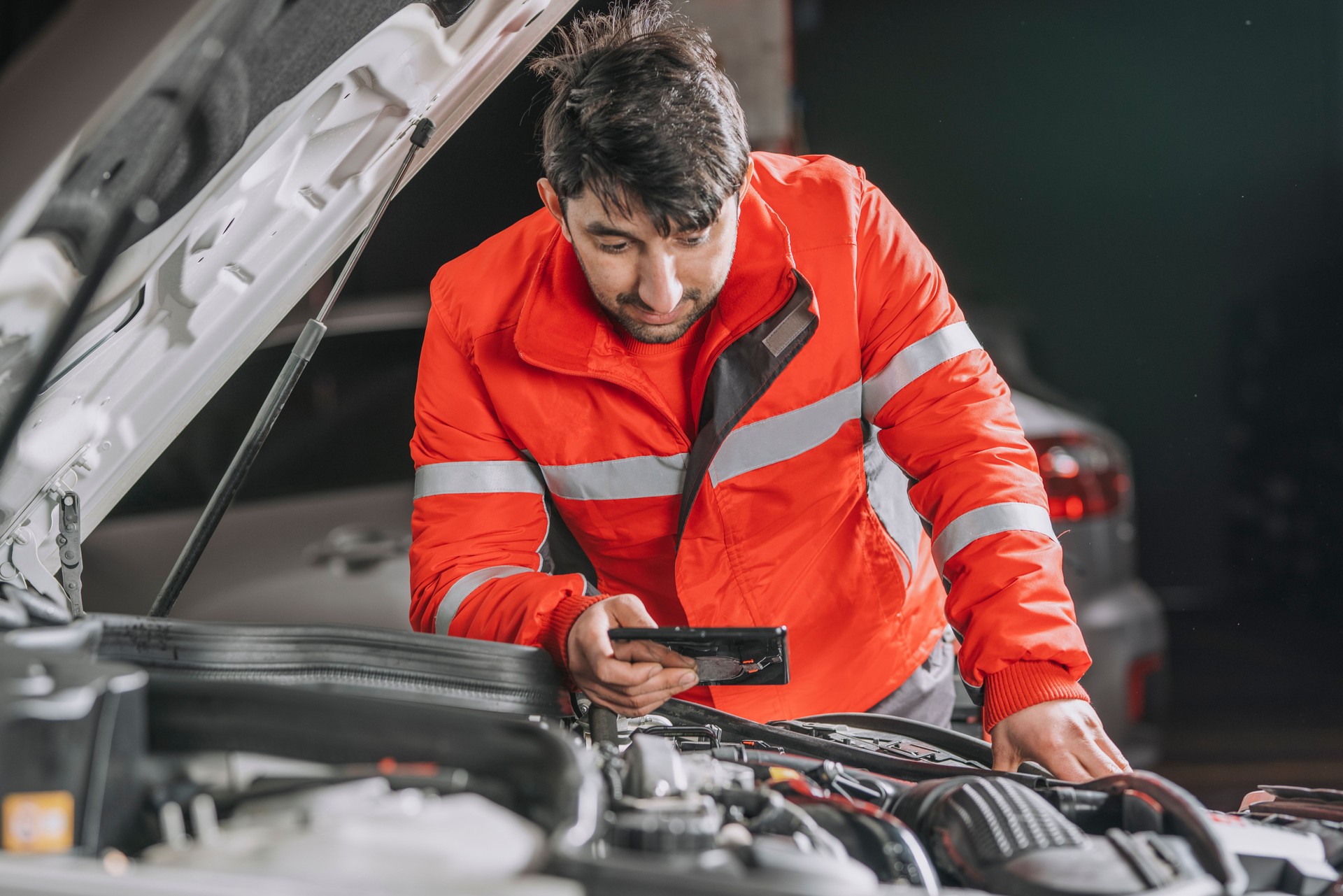 Auto mechanic uses the tablet to check.